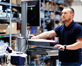 A guy working in warehouse on a monitor